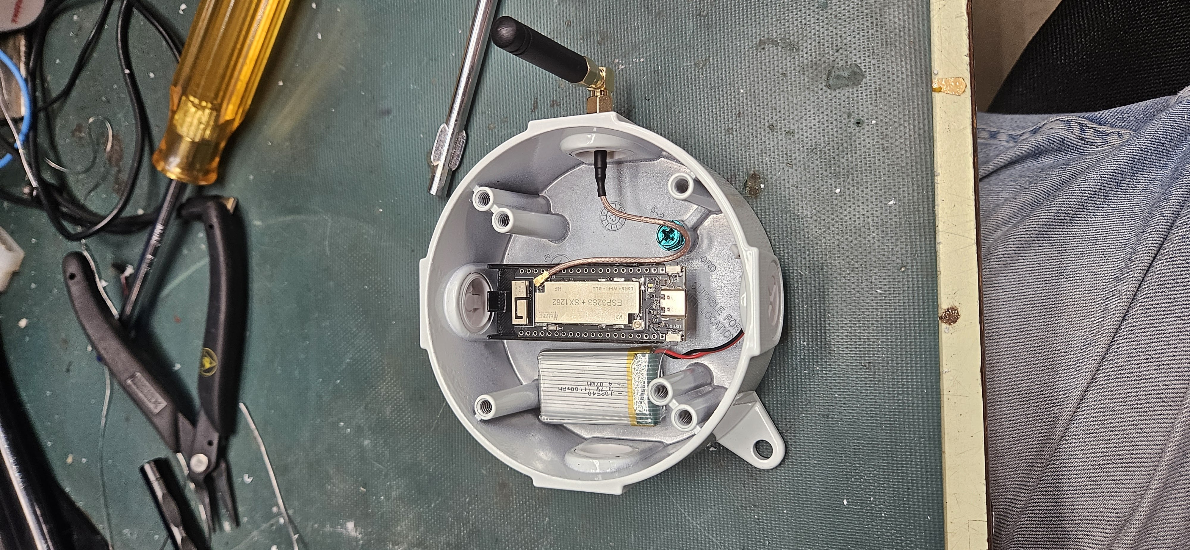 Initial internal fitment showing Heltec board, battery, and SMA ground connection inside round metal enclosure