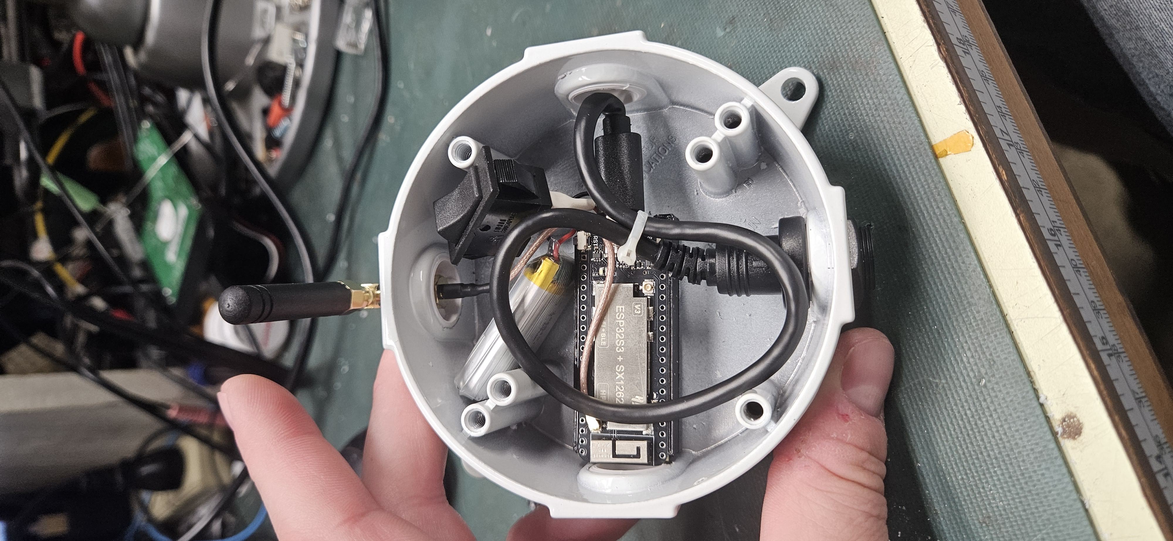 Fully wired interior showing USB-C cable routing, power switch, battery, and side-mounted antenna connector